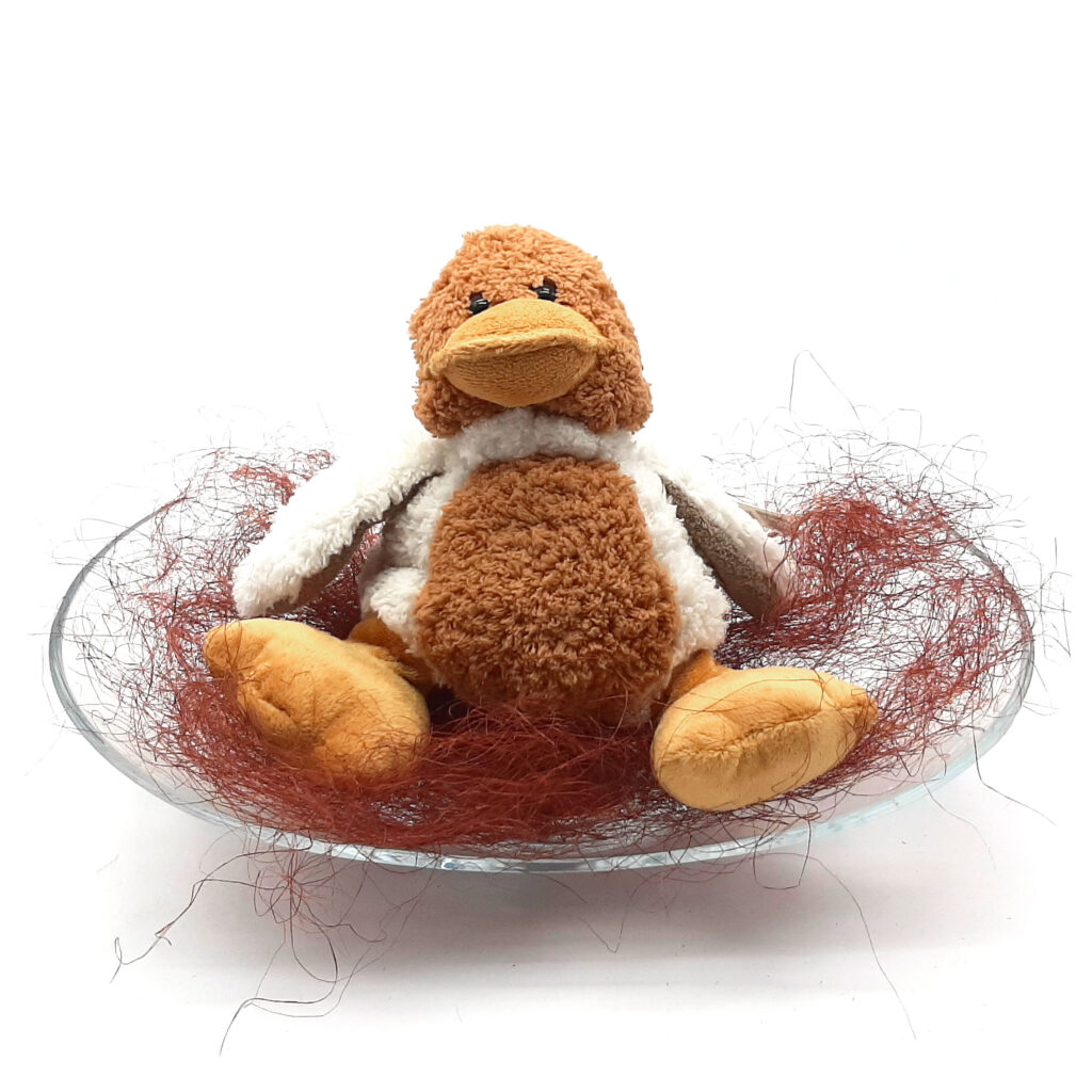 Composizione piatto in vetro con papero peluches